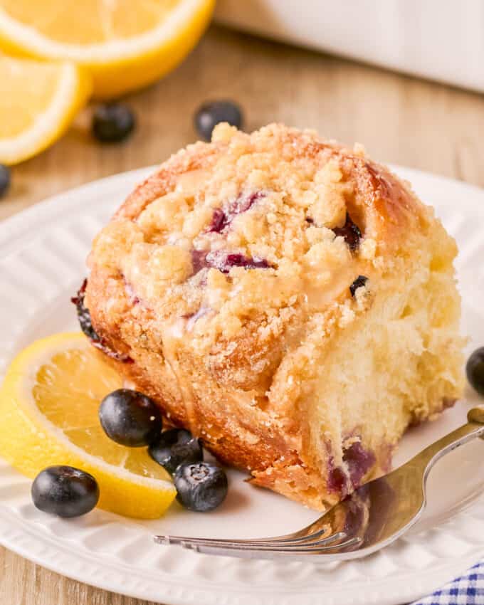 sweet roll with blueberries on plate with fork