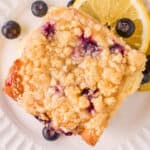 blueberry sweet roll on white plate with lemon slices and blueberries