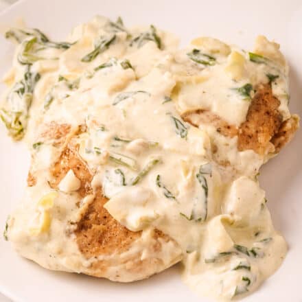 spinach and artichoke chicken on white plate