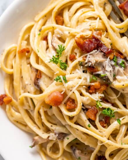 Creamy Mushroom Pasta is loaded with golden brown seared mushrooms and smothered in a silky and oh so creamy garlic parmesan sauce. With two simple swaps it can be made vegetarian, and while it's really easy to make, it looks (and tastes) fancy enough for a special occasion dinner!