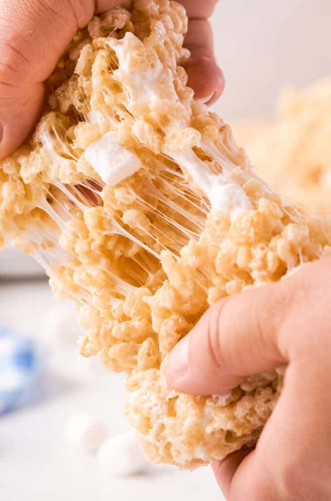 pulling apart a rice krispie treat showing the gooey marshmallows
