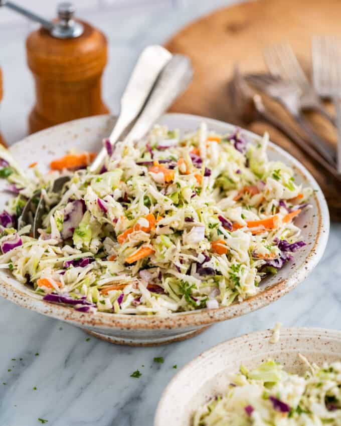 This classic and easy Coleslaw Recipe is made with crisp cabbage and carrots in a creamy, sweet and tangy homemade dressing! Perfect to make ahead, and great as a side dish or on top of a bbq sandwich!