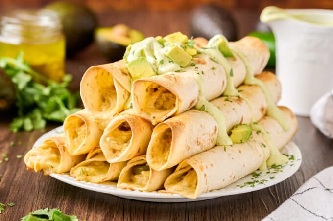 stack of baked taquitos on white plate