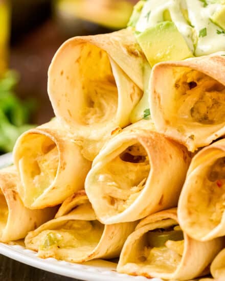 These Jalapeño Popper Chicken Taquitos are the perfect crowd-pleasing appetizer, or fun main course! Creamy jalapeño studded chicken filling is rolled up with cheese in flour tortillas and baked until crispy. Serve with an easy avocado-cilantro ranch and watch them disappear!