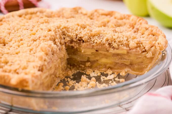 pie pan with apple pie and a slice taken out of it so you can see the inside of the pie