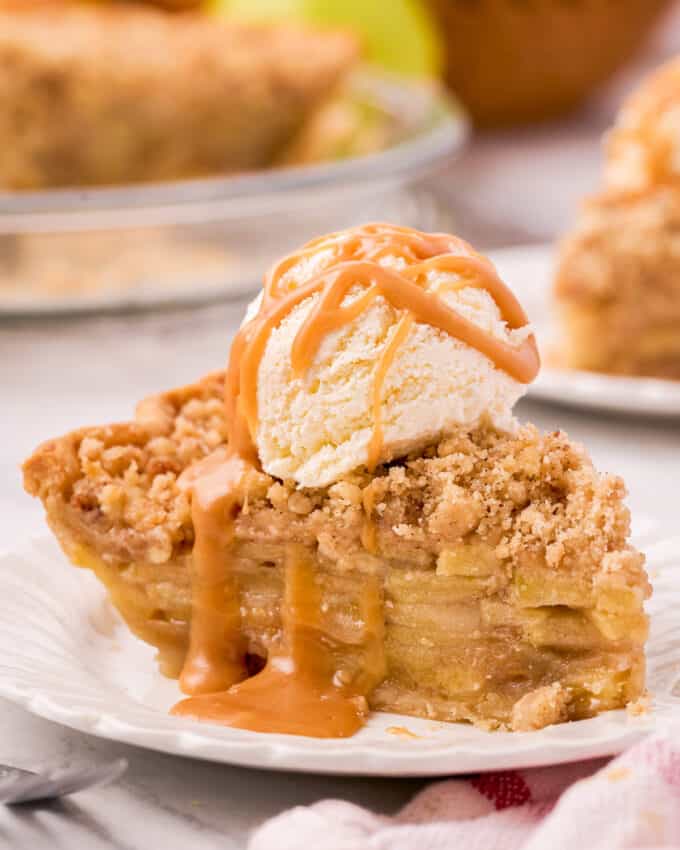 slice of apple pie topped with vanilla ice cream and caramel sauce