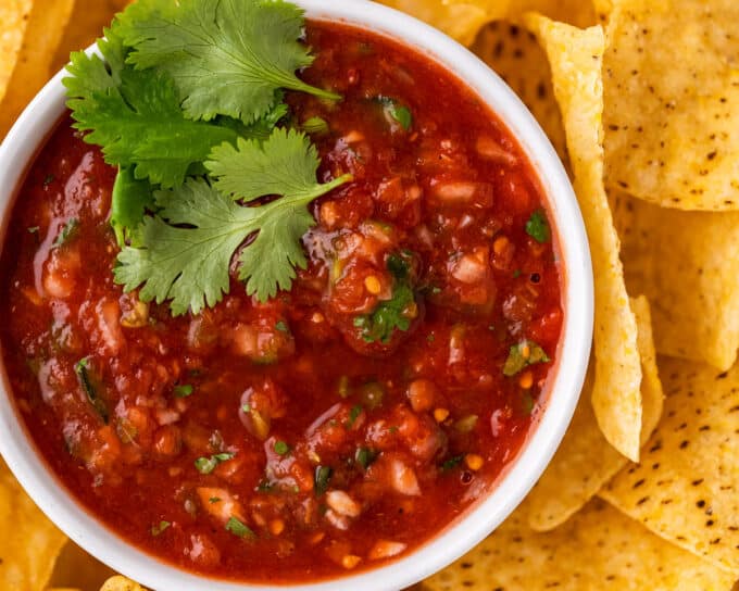 overhead view of a bowl of homemade salsa surrounded by tortilla chips