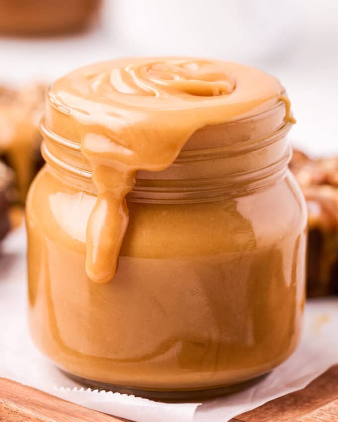 caramel sauce spilling over the rim of a glass jar