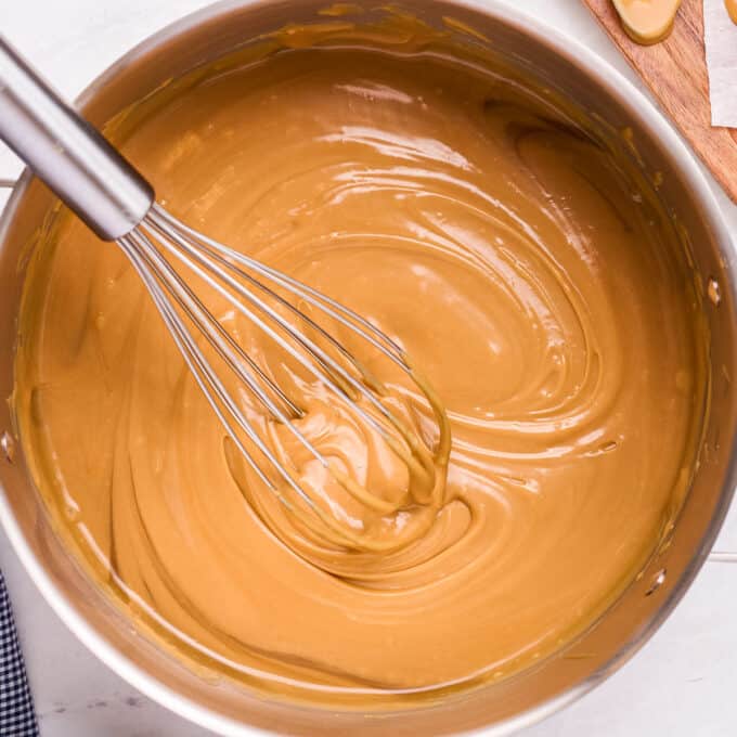 saucepan of caramel sauce stirred with a whisk