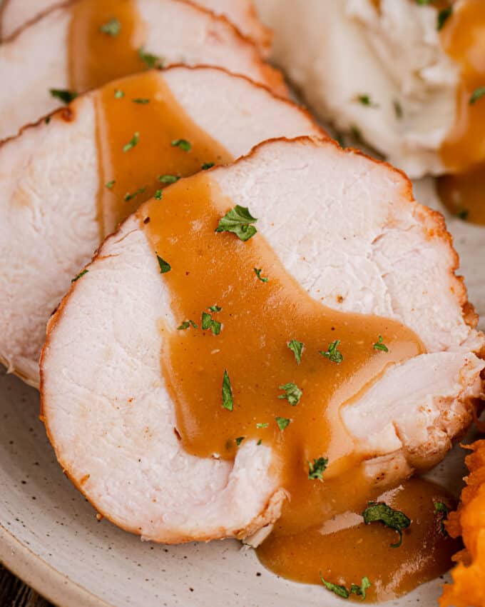 gravy drizzled on slices of turkey breast