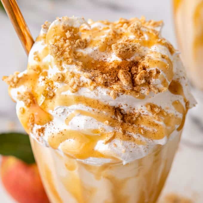 apple pie milkshake with whipped cream on top with graham cracker crumbs and caramel
