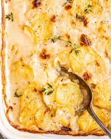 Thinly sliced potatoes are layered with sautéed onions, an easy homemade cream sauce, and some Parmesan cheese and baked until tender, golden brown and bubbly! Perfect for Thanksgiving, Christmas, Easter, or just a big family dinner... this is one side dish you need on your table!