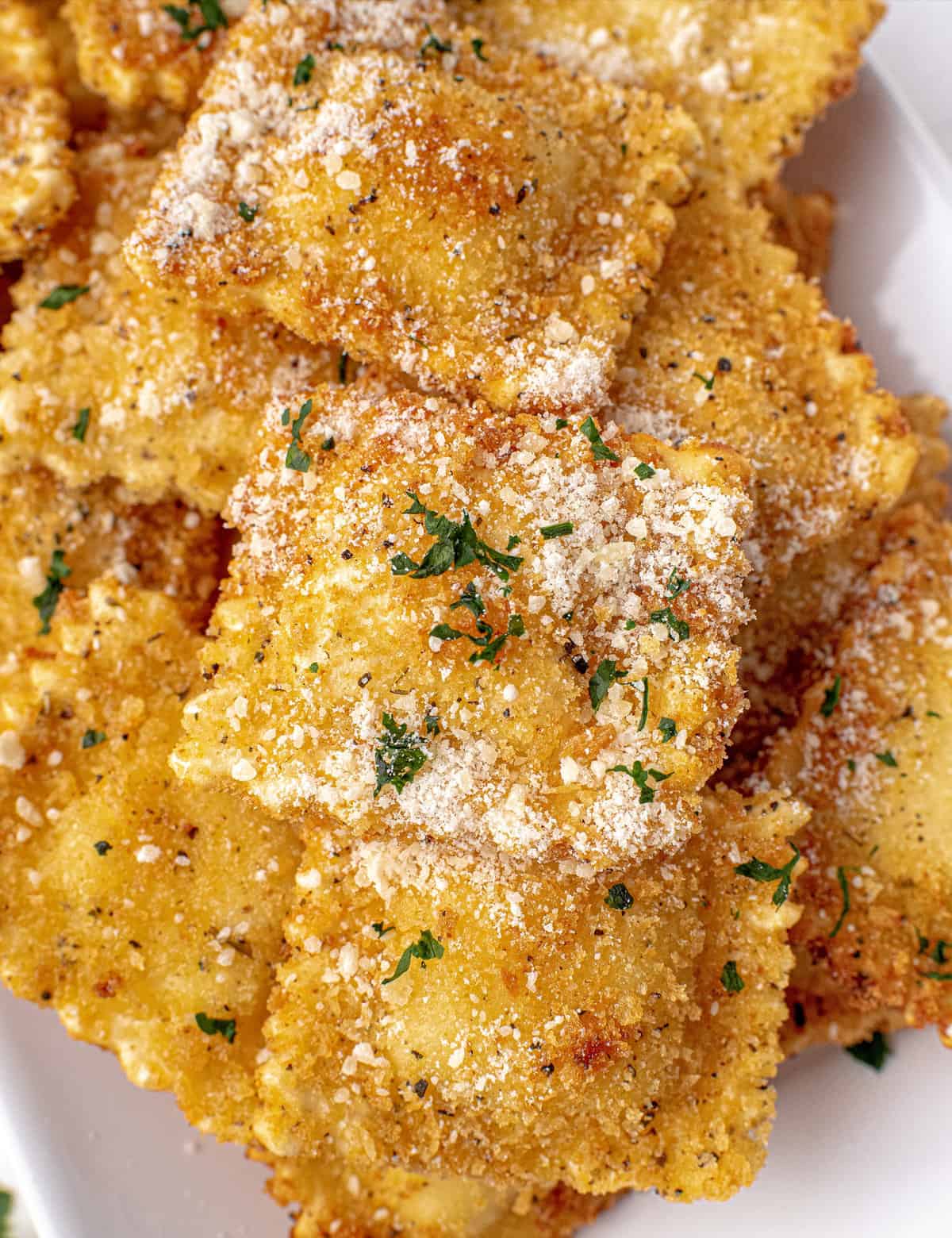This Fried Ravioli recipe is made with frozen ravioli (meat, cheese, or veggie) that are coated in Italian panko breadcrumbs and fried until perfectly crispy and golden brown. Dust them with Parmesan cheese and serve alongside some marinara sauce and watch them disappear! Perfect as an appetizer, game day food, or a fun family dinner!