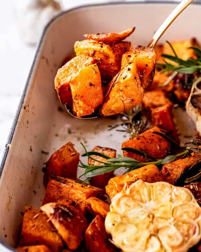 serving roasted sweet potatoes with a serving spoon