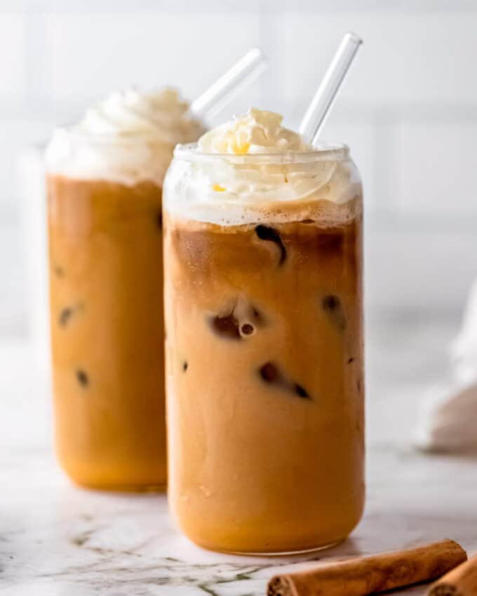 clear glass with iced latte and glass straw topped with whipped cream