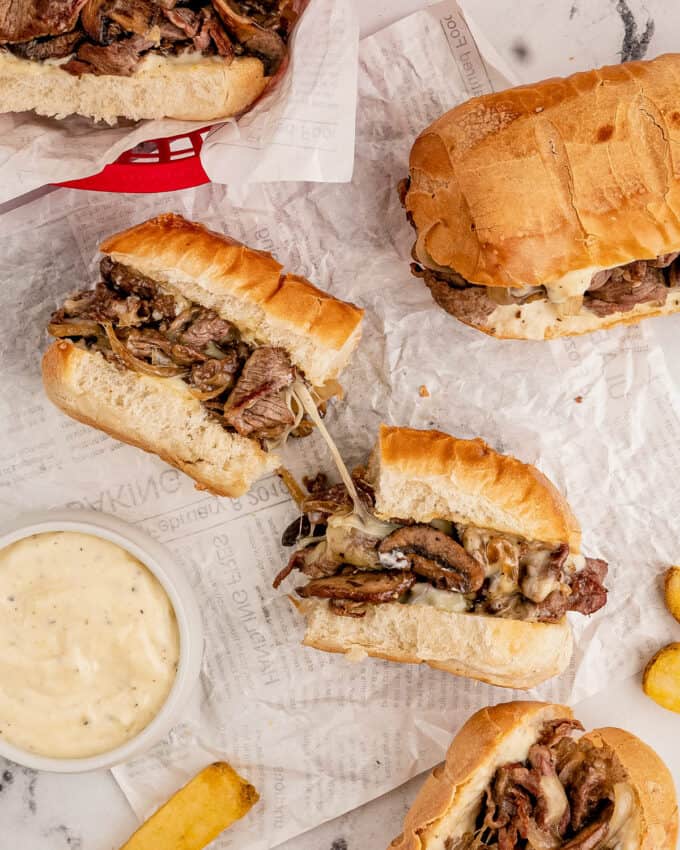 cheesesteak sliced in half with gooey cheese