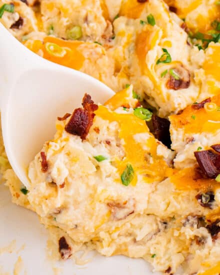 This must-make side dish is made with irresistibly creamy mashed potatoes, and loaded up with sour cream, cheddar cheese, crispy bacon, and fresh green onions! It's everything you love about a loaded baked potato, made into a make-ahead friendly casserole to feed a crowd!