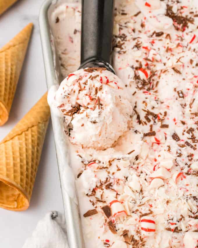 scooping out a big scoop of no churn peppermint ice cream from the loaf pan