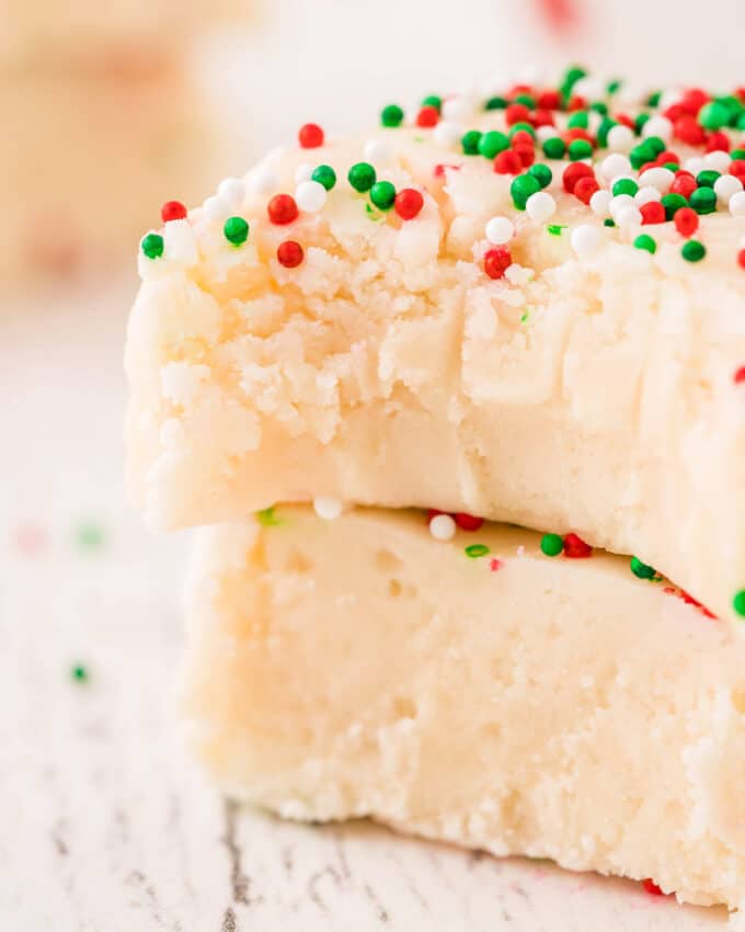 two squares of fudge stacked on top of each other, the top one has a bite taken out of it