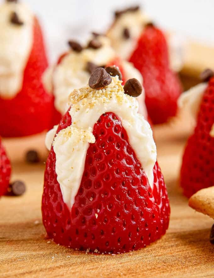 These fresh strawberries are filled with an easy 4 ingredient no-bake cheesecake filling, then sprinkled with graham cracker crumbs and mini chocolate chips! They're the perfect simple dessert to bring to a party or serve after dinner.