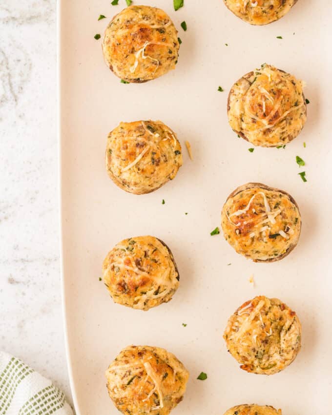 stuffed mushrooms lined up on a white platter