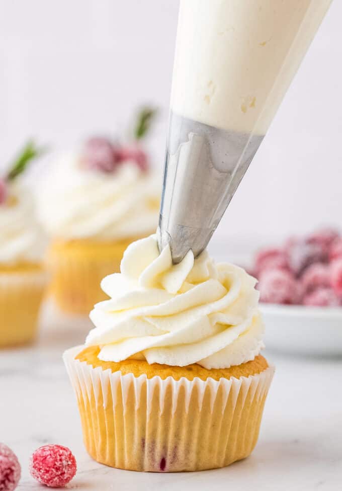 piping frosting onto cupcake