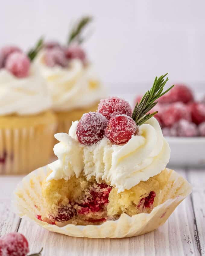 white chocolate cranberry cupcake with a bite taken out of it