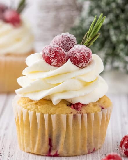 Fluffy and soft vanilla cupcakes studded with tart cranberries, topped with a decadent white chocolate buttercream frosting, and simple homemade sugared cranberries! Holiday baking has never been more delicious!