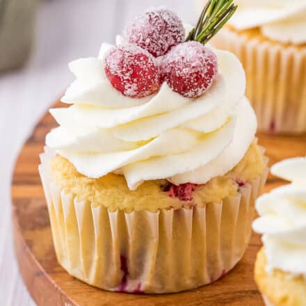 cranberry cupcake with white chocolate buttercream on wooden cutting board