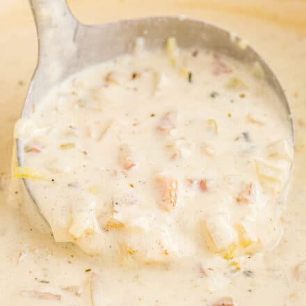 close up view of a ladle of clam chowder