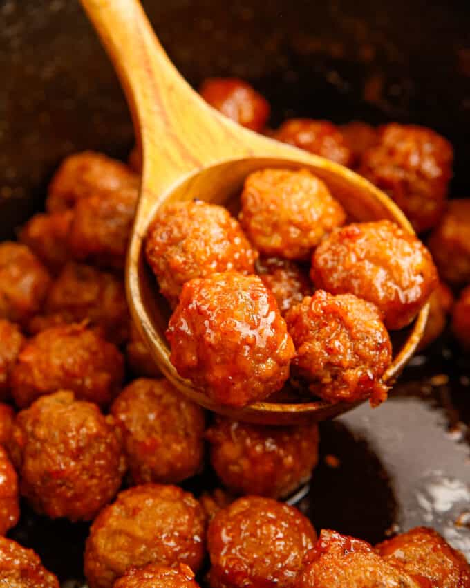 scoop of buffalo meatballs being served out of the crockpot