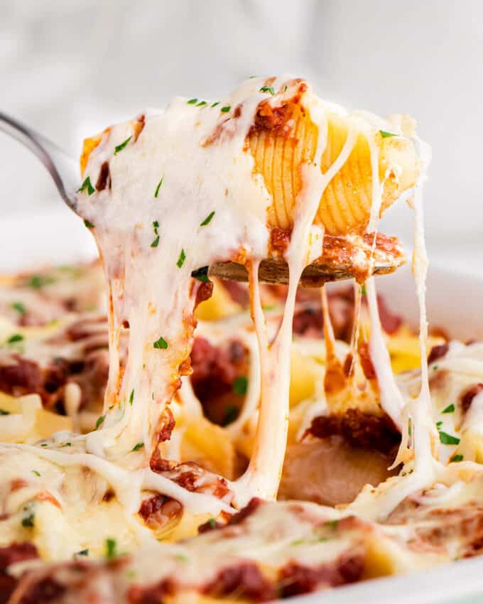 serving lasagna stuffed shells with gooey cheese