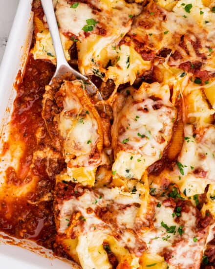 Al dente pasta shells are stuffed with a cheesy ricotta, spinach and garlic filling, then smothered in a hearty meat sauce and mozzarella cheese, then baked until bubbly and golden brown! Perfect for a big family dinner and as a freezer-meal!
