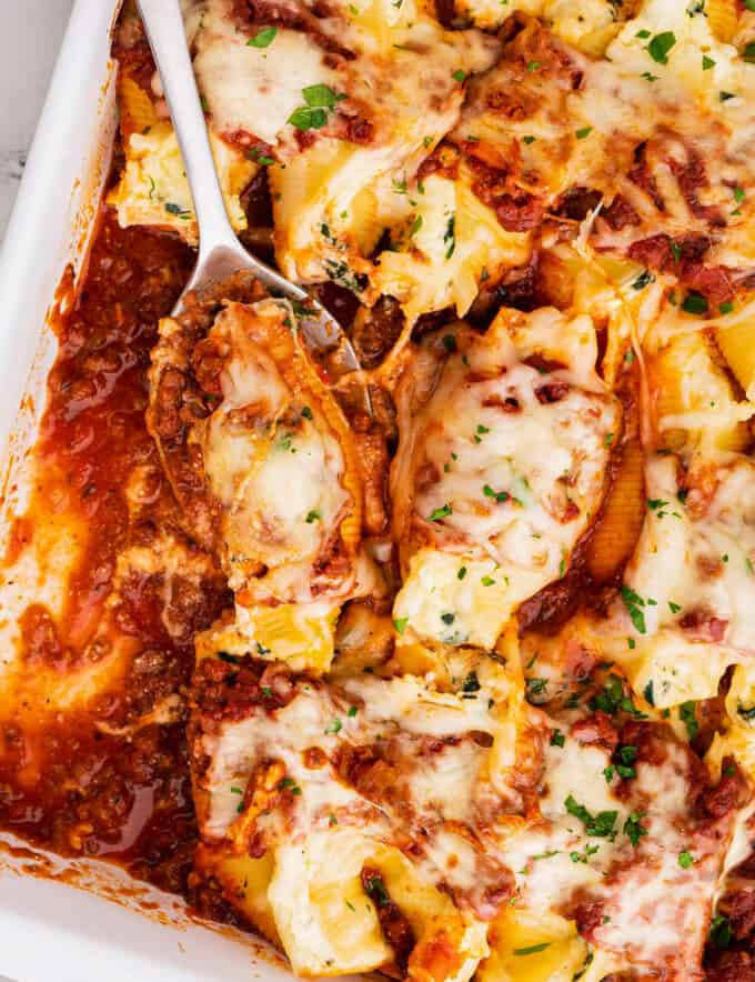 Al dente pasta shells are stuffed with a cheesy ricotta, spinach and garlic filling, then smothered in a hearty meat sauce and mozzarella cheese, then baked until bubbly and golden brown! Perfect for a big family dinner and as a freezer-meal!