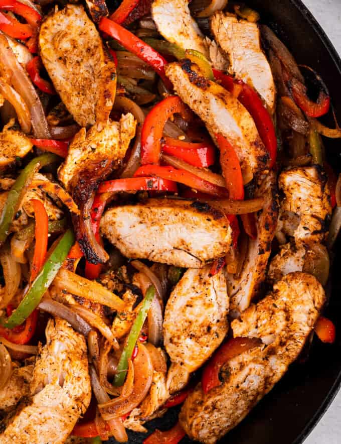 Juicy chicken, quickly marinated with a homemade fajita seasoning blend, seared and lightly charred with peppers and onions, all in the same skillet. Great in tacos, bowls, burritos, or just eaten with a fork. The perfect Tex-Mex weeknight dinner idea!