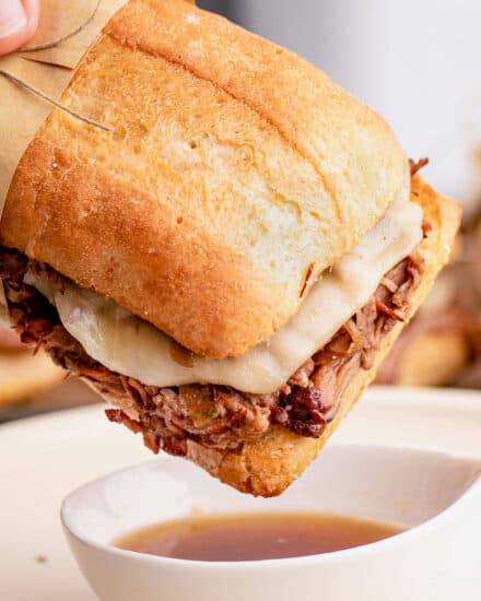 These Slow Cooker French Dip Sandwiches are made with ultra tender roasted beef, melted provolone cheese, soft hoagie bread, and dipped into an amazing au jus sauce. Perfect cold weather comfort food for the whole family!