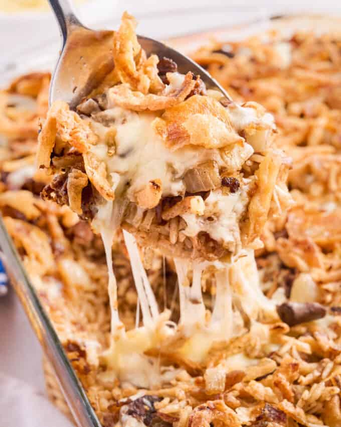 serving a portion of french onion baked rice casserole with cheese