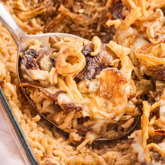 close up photo of a serving spoon full of rice casserole with beef and mushrooms