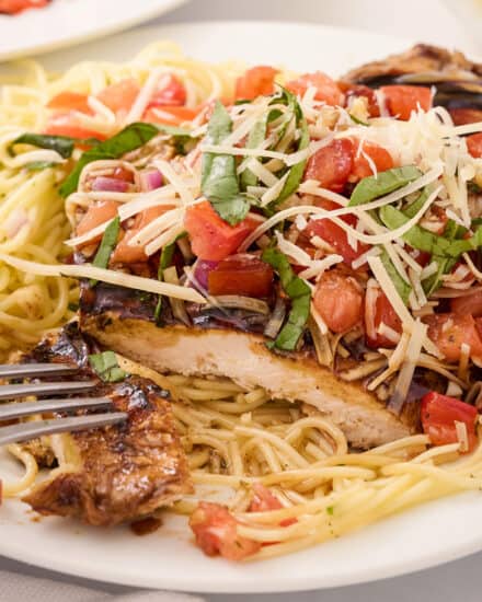 This bruschetta chicken pasta combines marinated and grilled chicken, topped with a fresh summer bruschetta, and served with a light white wine pasta. It’s a great spring and summer dinner idea that the whole family will love!