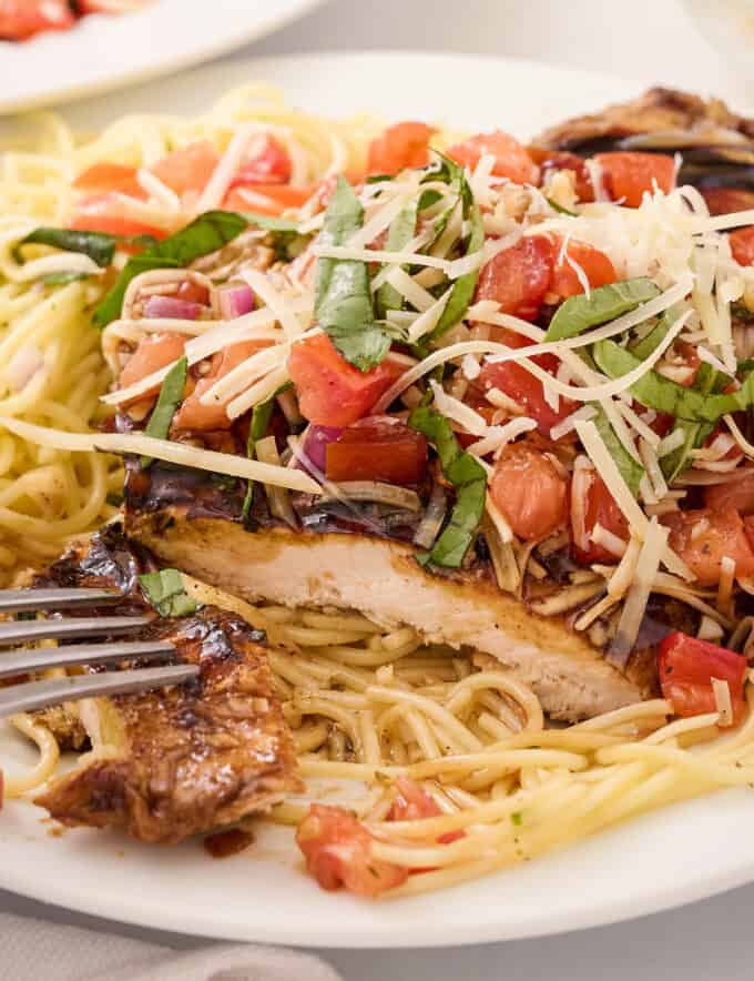 This bruschetta chicken pasta combines marinated and grilled chicken, topped with a fresh summer bruschetta, and served with a light white wine pasta. It’s a great spring and summer dinner idea that the whole family will love!