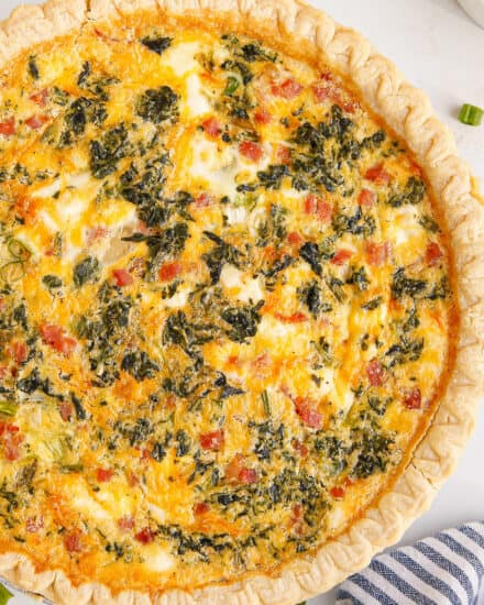 This quiche recipe is loaded with savory flavors like ham, cheese, spinach, cream cheese, green onions and more! Plus it can be made with a homemade OR store-bought pie crust, can be prepped ahead, and is perfect for a holiday brunch!