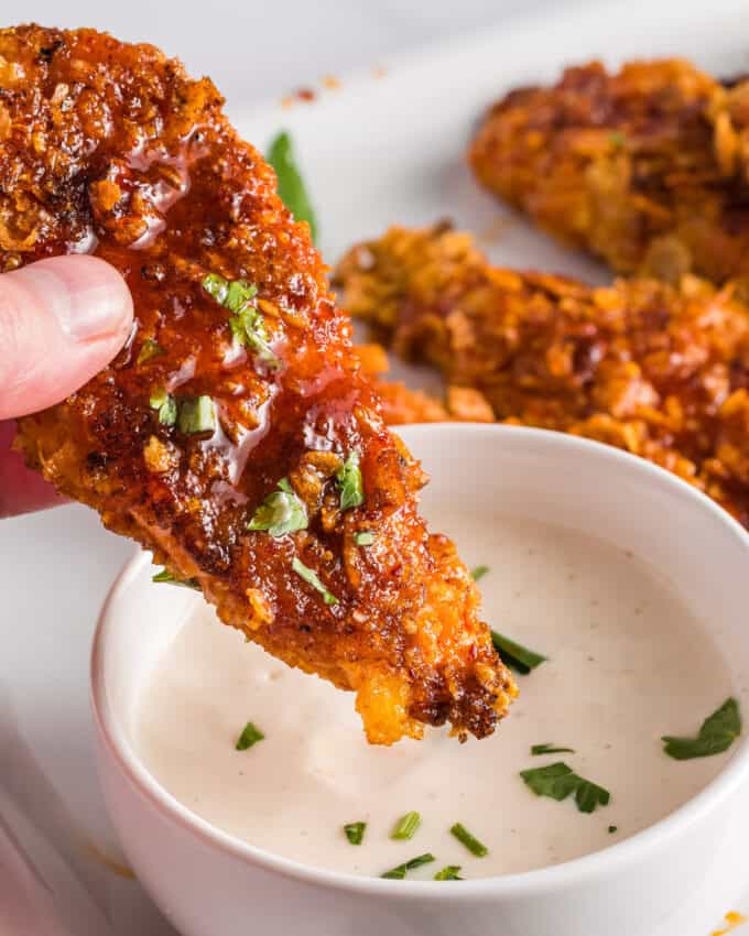 dipping an air fried chicken tender in ranch dressing