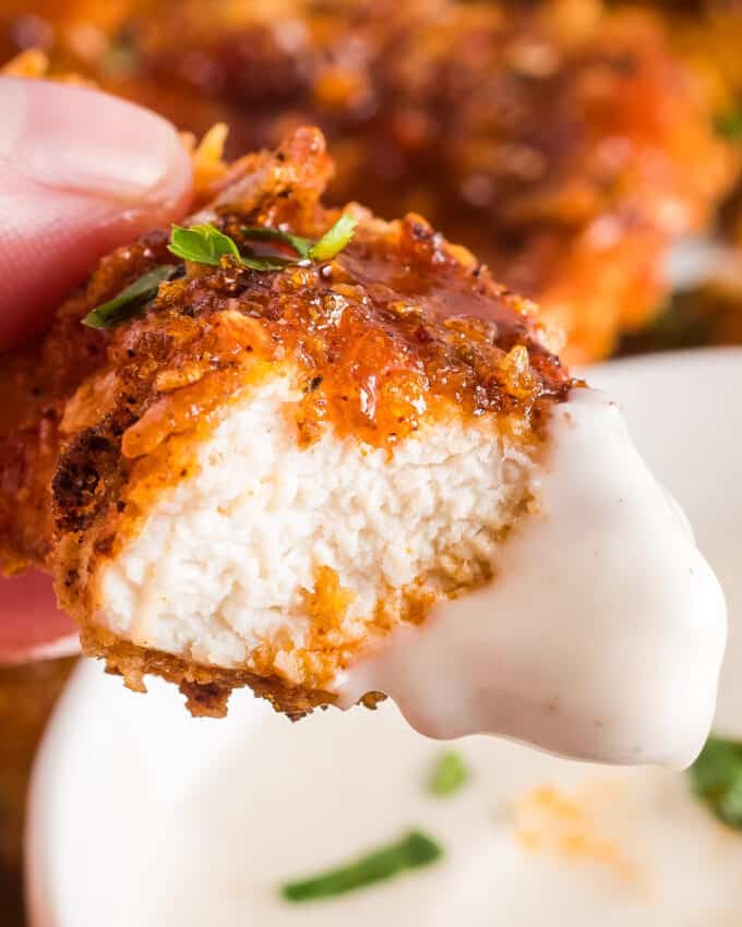 air fryer chicken tender dipped in ranch and bitten in half.