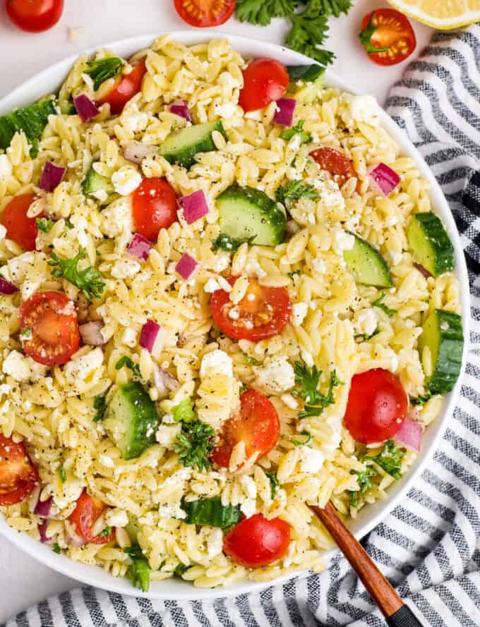 white bowl filled with orzo salad with tomatoes and cucumbers