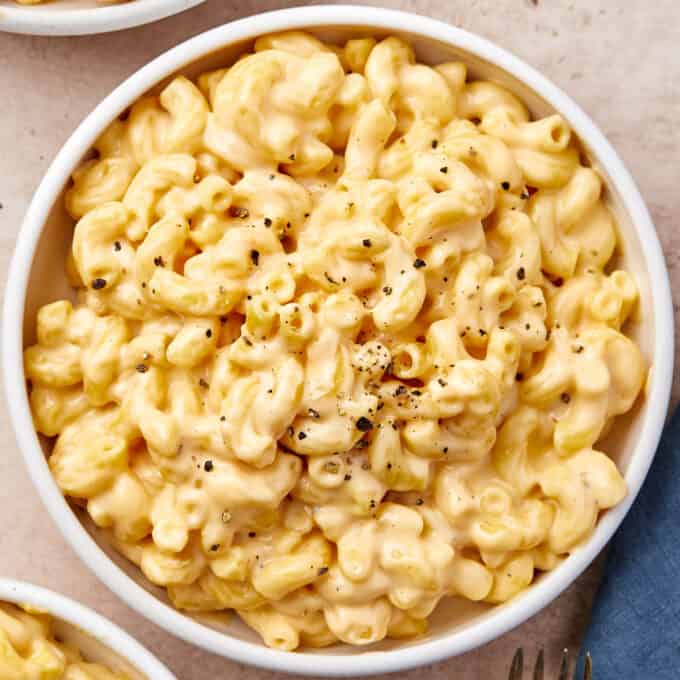 overhead photo of a white bowl of mac and cheese sprinkled with pepper