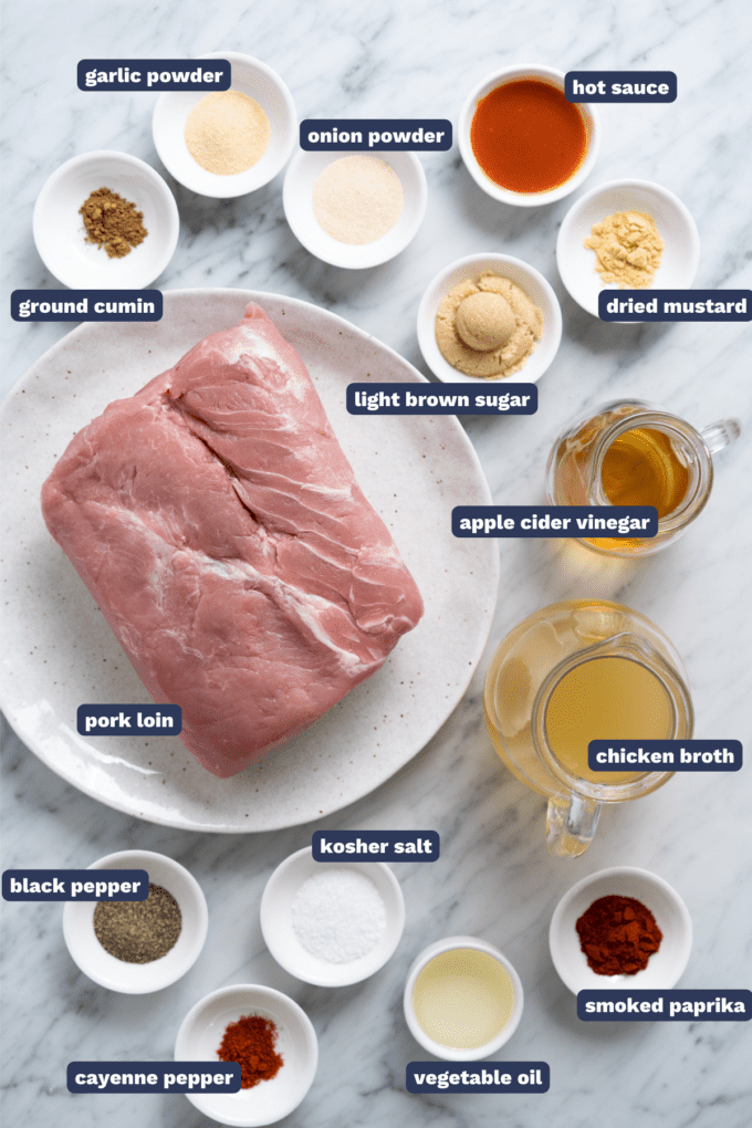 ingredients for making pulled pork lined up on a marble counter.