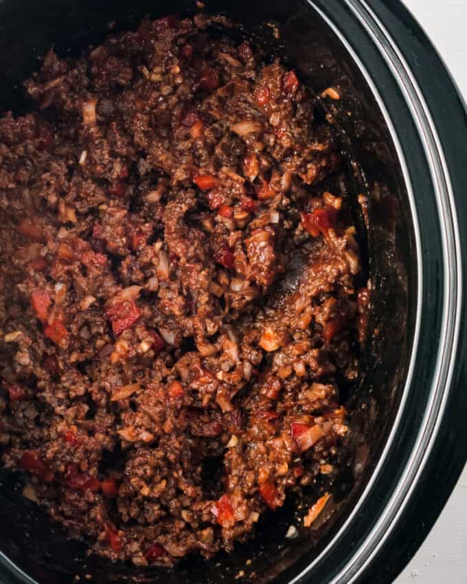 homemade sloppy joe mixture in a black oval slow cooker.