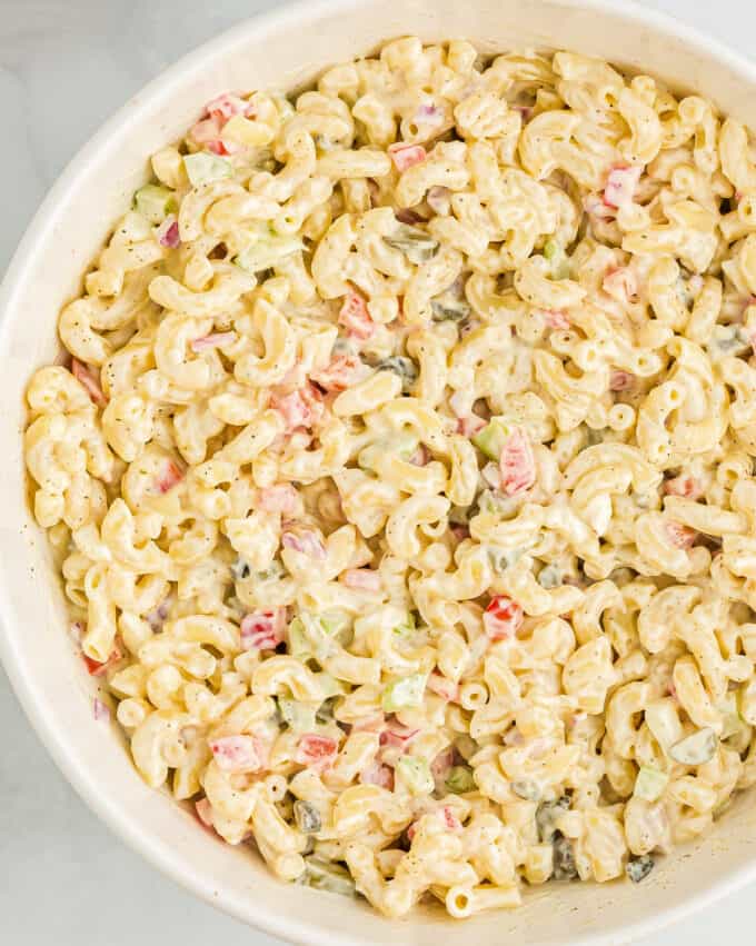 overhead view of a large white serving bowl of creamy pasta salad