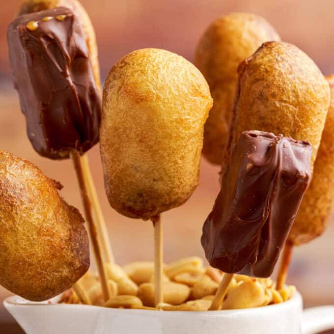 fried snickers on bamboo skewers stuck down into a jar