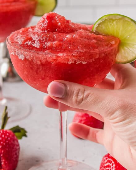 These Frozen Strawberry Margaritas are made with just a handful of ingredients, and made easily in a food processor or blender! Perfect for a hot summer day, this recipe includes not only the boozy classic version, but also a "virgin" mocktail version.